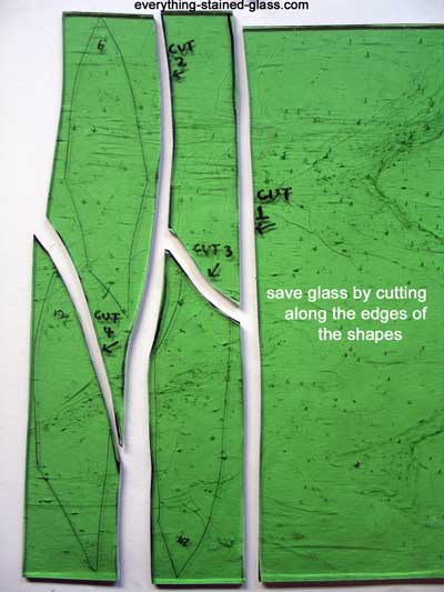 four rough shapes cut from green glass